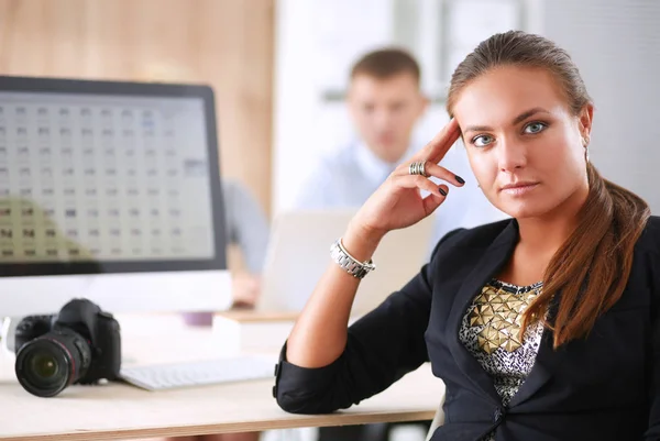 Jeune femme au bureau, assise au bureau — Photo