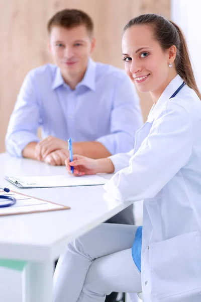 Médico mulher sentada com paciente do sexo masculino na mesa — Fotografia de Stock