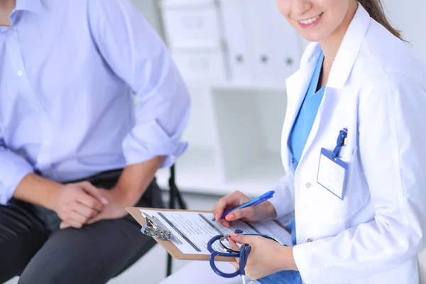 Doctor vrouw zitten met mannelijke patiënt aan de balie — Stockfoto