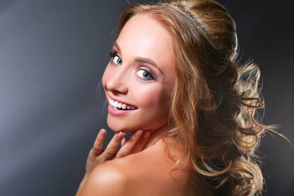 Beautiful woman with curly long hair on dark background — Stock Photo, Image