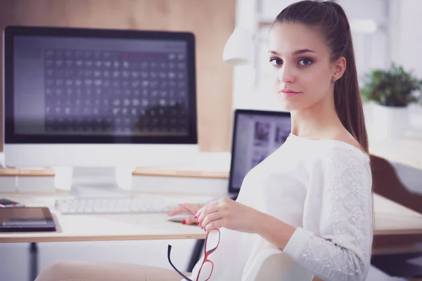 Mujer joven trabajando en la oficina, sentada en el escritorio — Foto de Stock