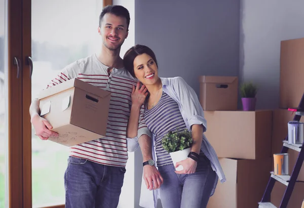 Cuplu tânăr fericit despachetează sau împachetează cutii și se mută într-o casă nouă — Fotografie, imagine de stoc