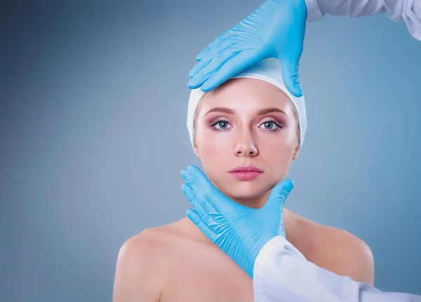 Kosmetikspritze auf das hübsche Frauengesicht. isoliert auf grauem Hintergrund — Stockfoto
