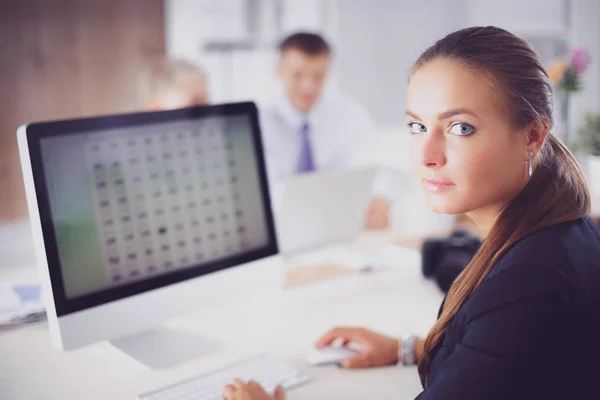 Mujer joven trabajando en la oficina, sentada en el escritorio — Foto de Stock