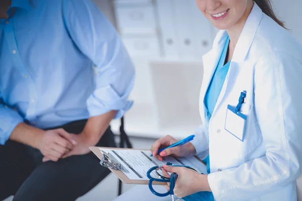 Médecin femme assise avec un patient masculin au bureau — Photo