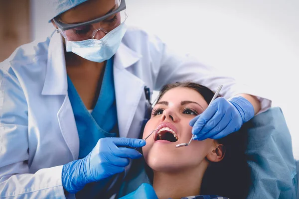 Mulher dentista trabalhando em seus pacientes dentes — Fotografia de Stock