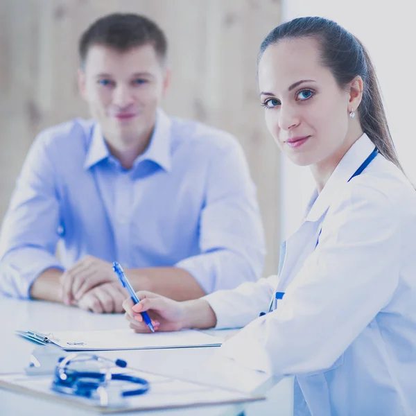 Médecin femme assise avec un patient masculin au bureau — Photo