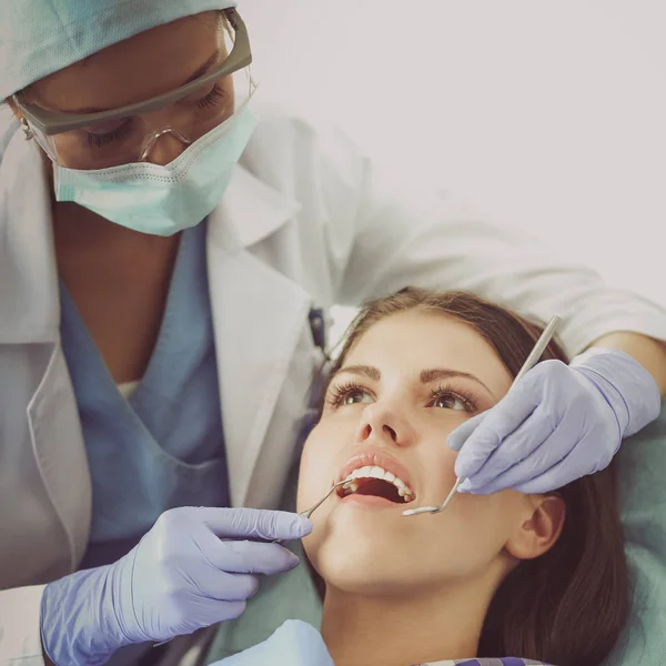 在病人牙齿上工作的女牙医 — 图库照片