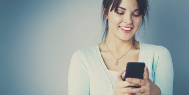 Akıllı telefon kullanan ve okuyan bir kadın