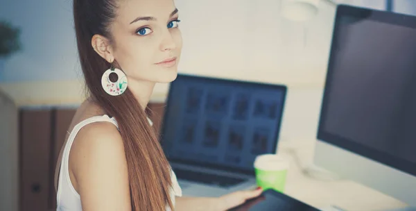 Porträtt av en attraktiv ung affärskvinna som sitter framför en dator. — Stockfoto