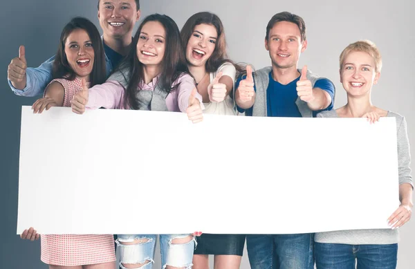 Grupo feliz de pessoas de diferentes profissões segurando um cartaz em branco. — Fotografia de Stock
