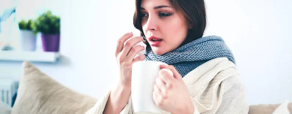 Portrait d'une femme malade se mouchant alors qu'elle était assise sur le canapé — Photo