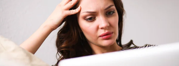 Mujer bonita feliz usando el ordenador portátil sentado en el sofá — Foto de Stock