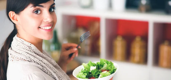 Ung kvinna som håller i matkassen med grönsaker Står i köket — Stockfoto