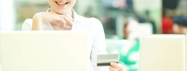 Donna d'affari sorridente che fa shopping online tramite laptop e carta di credito in ufficio — Foto Stock