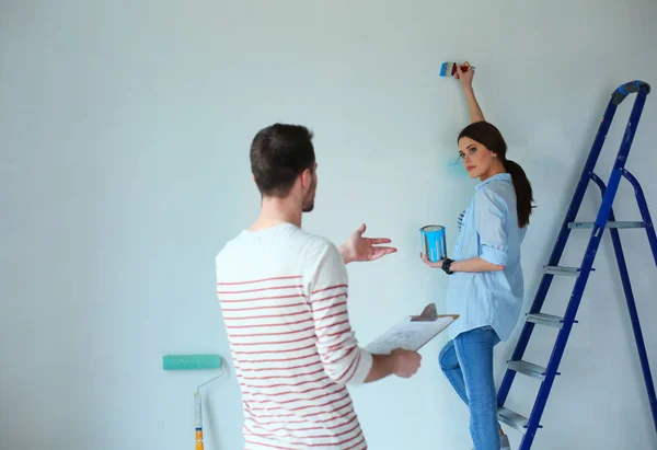 Portrait of happy smiling young couple painting interior wall new house — Stock Photo, Image