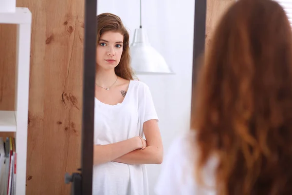 Schöne Mädchen, die in den Spiegel schauen und Kosmetik mit einem großen Pinsel anwenden — Stockfoto