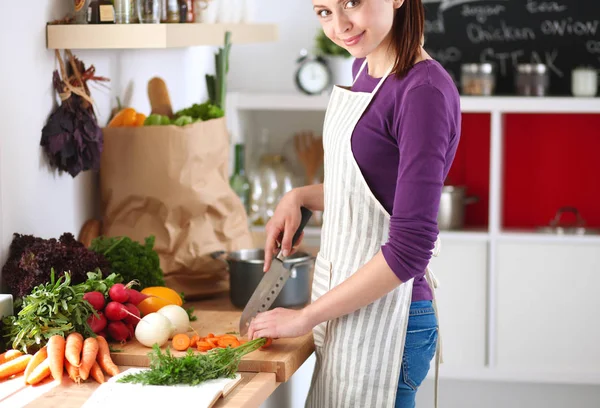 Young woman cutting vegetables in the kitchen — Stock Photo, Image