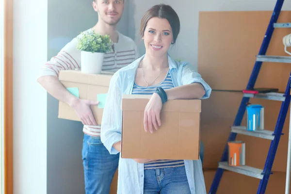 Glada unga par uppackning eller packa lådor och flyttar till ett nytt hem — Stockfoto