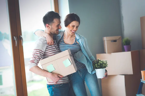 Šťastný mladý pár rozbalení nebo balení krabic a stěhování do nového domu — Stock fotografie