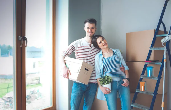 Glada unga par uppackning eller packa lådor och flyttar till ett nytt hem — Stockfoto