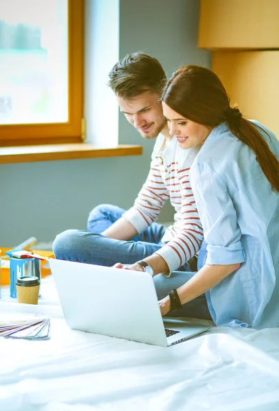 Jong koppel zittend op de vloer van hun nieuwe appartement — Stockfoto