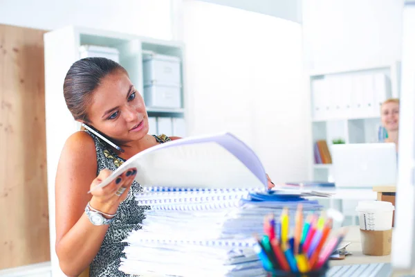 Junge Frau arbeitet im Büro, sitzt am Schreibtisch mit Ordner — Stockfoto