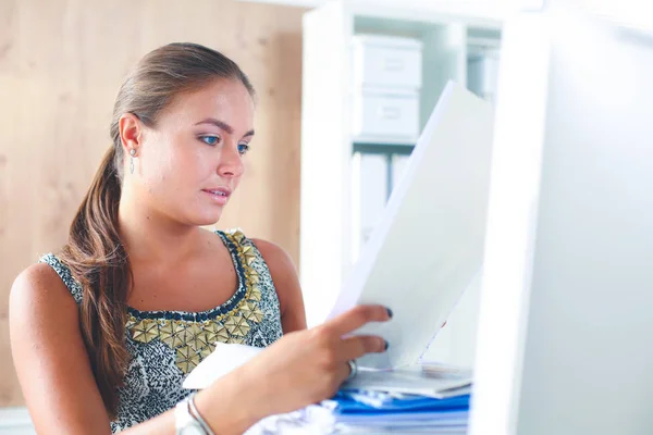 Junge Frau arbeitet im Büro, sitzt am Schreibtisch mit Ordner — Stockfoto