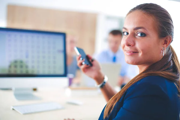 Jonge vrouw die werkt in office zit aan bureau met map — Stockfoto