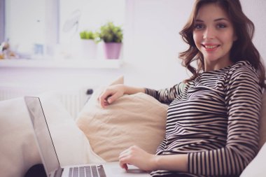 Koltukta oturan dizüstü kullanan mutlu güzel kadın