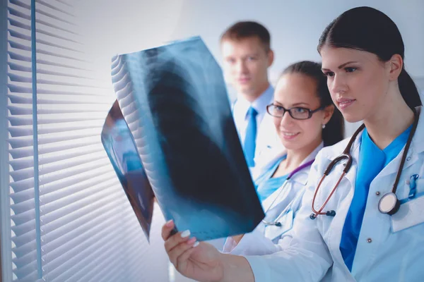 Genç bir grup doktor röntgene bakıyor. — Stok fotoğraf