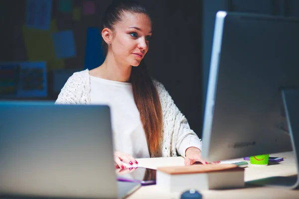 Jonge vrouw werkt in het kantoor, zit aan het bureau — Stockfoto