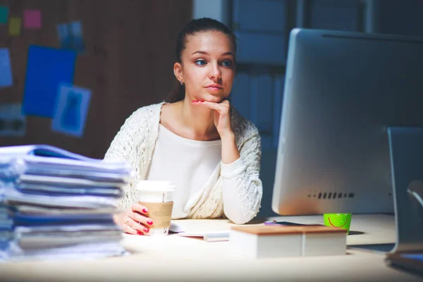 Jovem mulher trabalhando no escritório, sentada na mesa — Fotografia de Stock