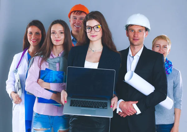 Leende affärskvinna med bärbar dator och grupp av industriarbetare — Stockfoto