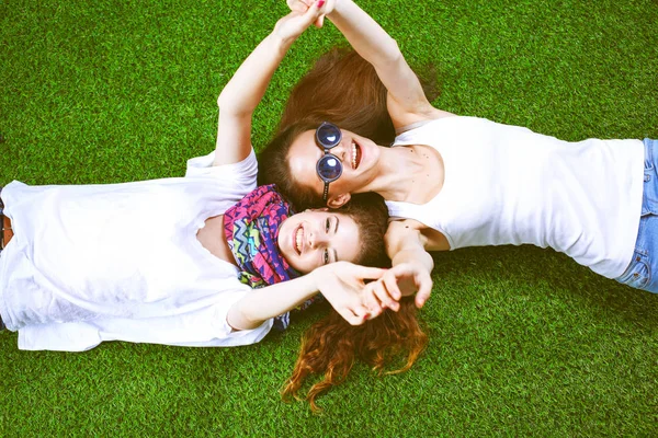 Two pretty girls lying on the fresh green grass — Stock Photo, Image