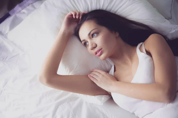 Pretty woman lying in bed at home — Stock Photo, Image