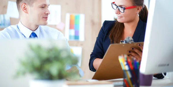 Fashion designers working in studio sitting on the desk — Stock Photo, Image