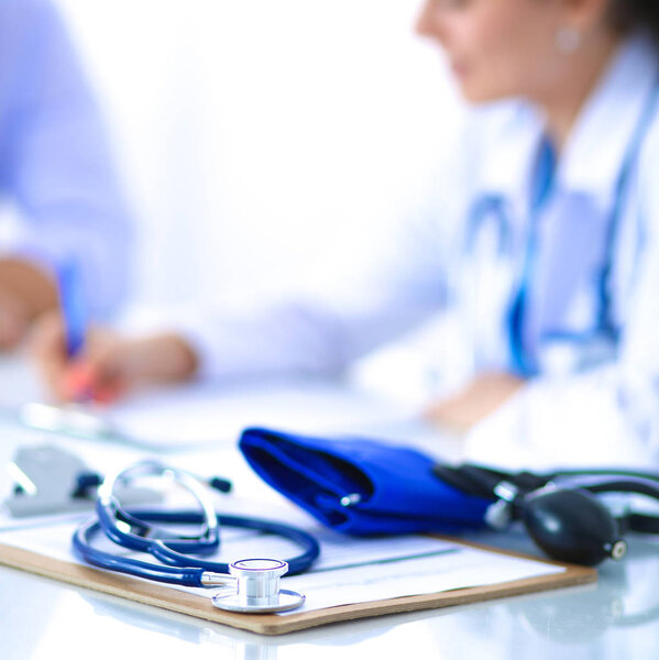 Portrait of young female doctor sitting at desk in hospital