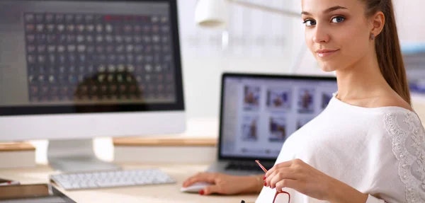 Portret van een aantrekkelijke jonge zakenvrouw zittend achter een computer. — Stockfoto