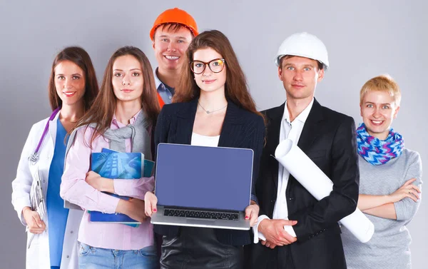 Glimlachende zakenvrouw met laptop en groep industriële werknemers — Stockfoto