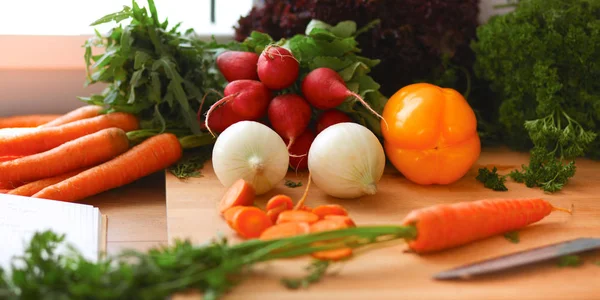 Mutfakta sebze doğrayan genç bir kadın.