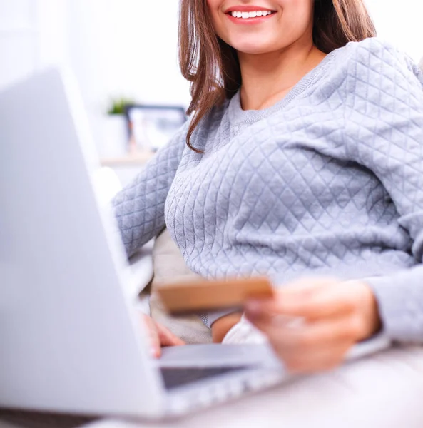Mulher sorridente bonita com laptop e um cartão de crédito — Fotografia de Stock