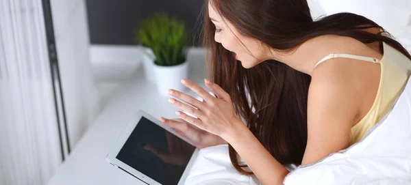 Women use a tablet pc on the bed — Stock Photo, Image