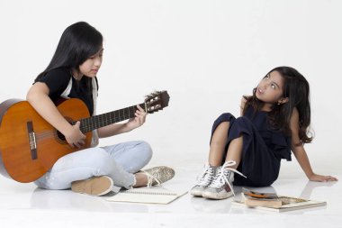 İki kız kardeş iskambil gitar ve kitap okumak
