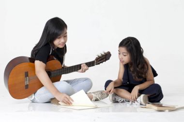 İki kız kardeş iskambil gitar ve kitap okumak