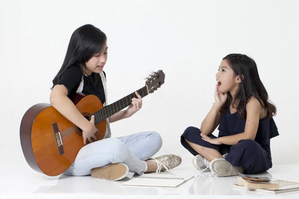 Two Sisters Playing Guitar Reading Book — Stock Photo, Image