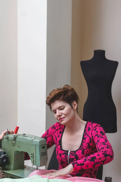 Genç bayan terzi stüdyodaki katalogdan malzeme seçiyor..