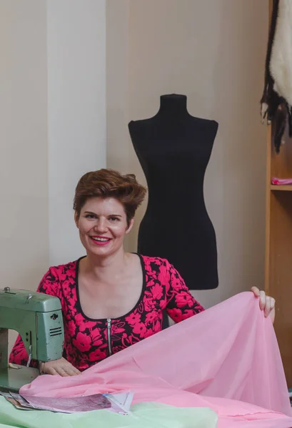 Genç bayan terzi stüdyodaki katalogdan malzeme seçiyor..