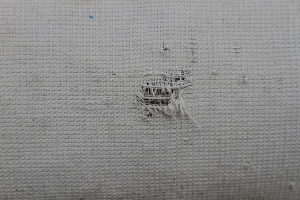 Arka plan olarak eski soluk kumaş üzerinde delik