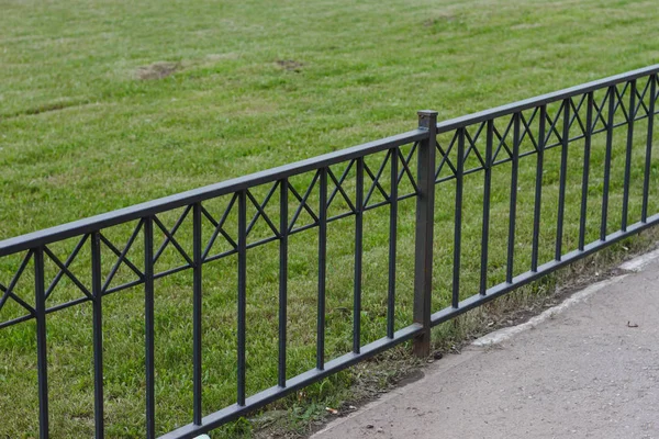 Yeşil çim ve sahte metal çit